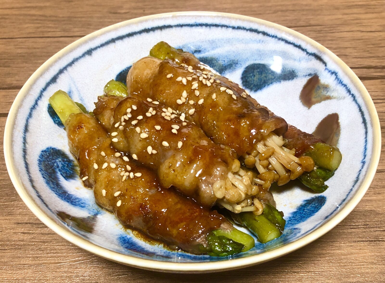 アスパラの肉巻きを盛り付けた青い模様の小皿