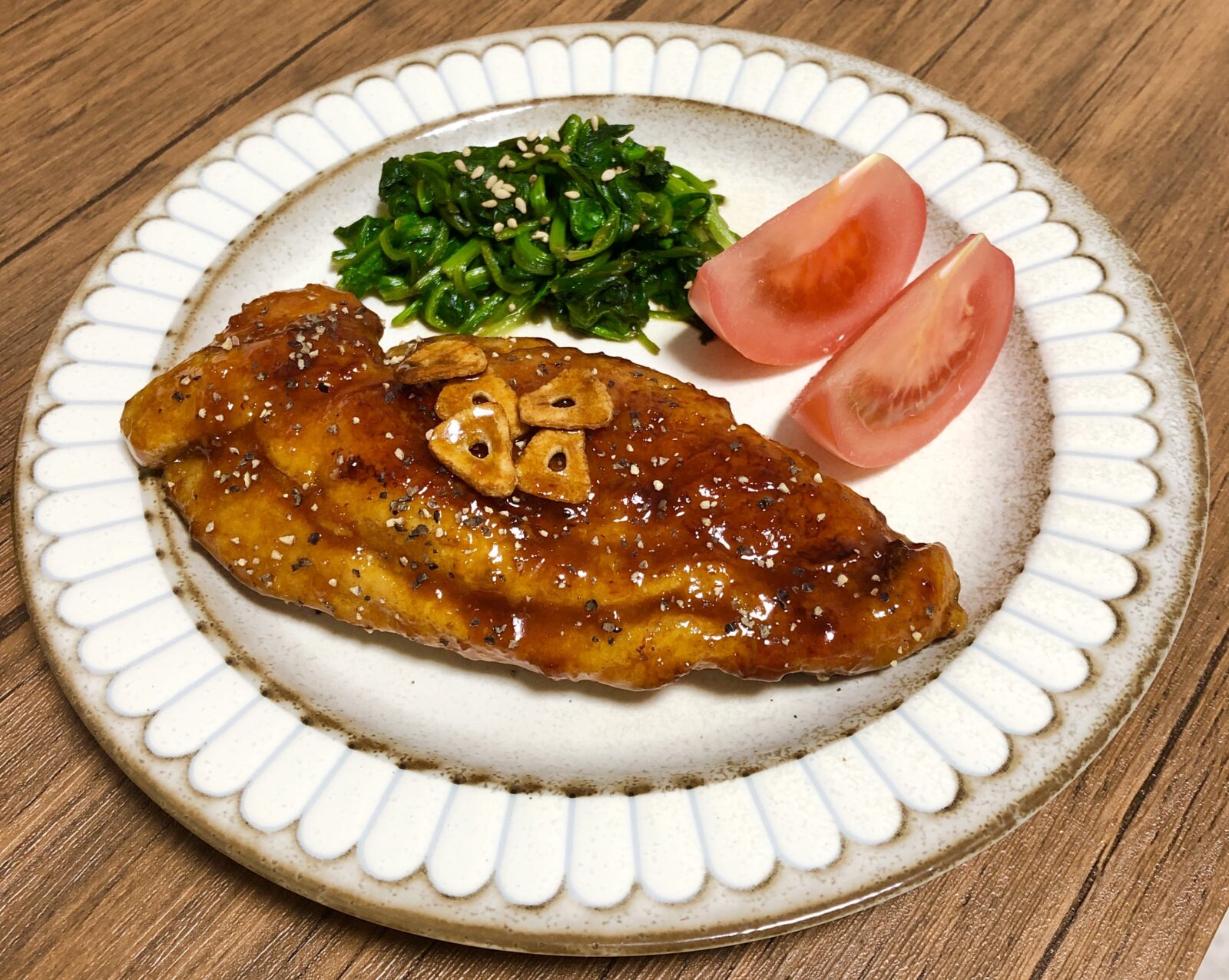 鶏むね肉の甘酢チキンを盛り付けた花びら縁の白い平皿